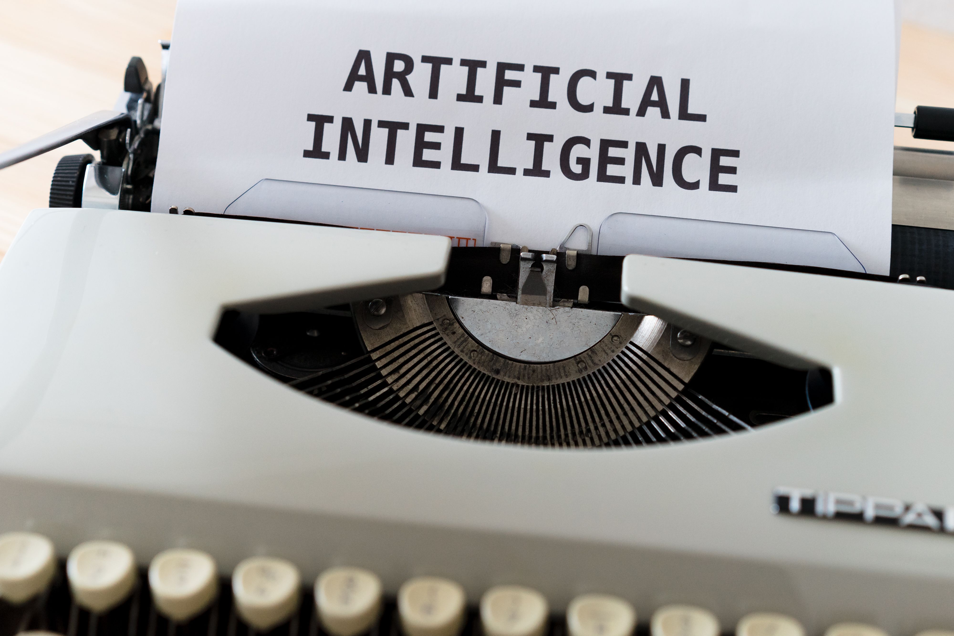 Close-up of a typewriter with the words 'Artificial Intelligence' typed on paper
